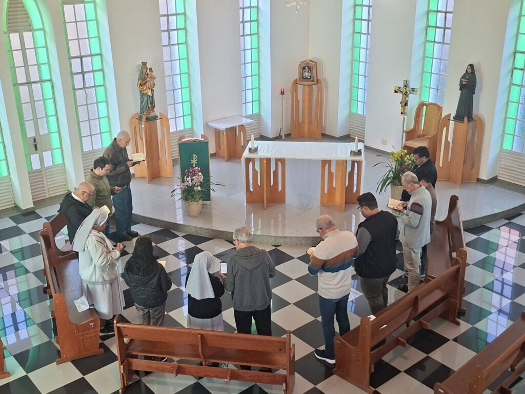 Frades franciscanos em círculo participando de um momento de oração e reflexão durante o retiro espiritual em Santa Luzia.