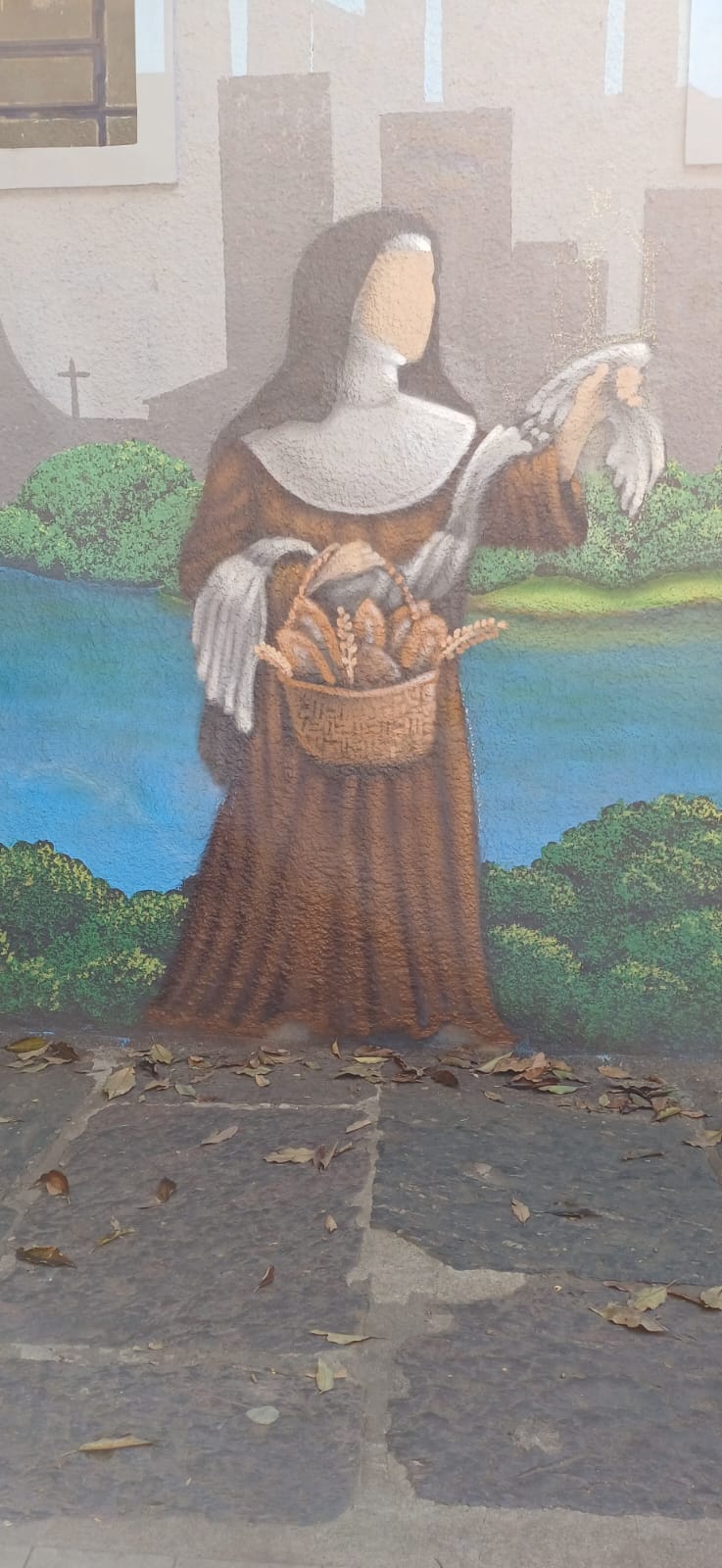 Destaque de Santa Clara com cesta de pães nas mãos